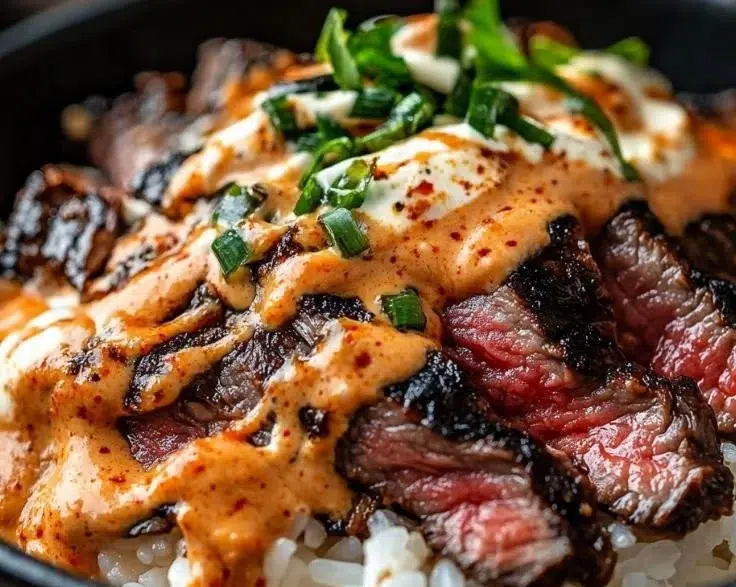 Delicious Korean BBQ steak rice bowl garnished with fresh vegetables.