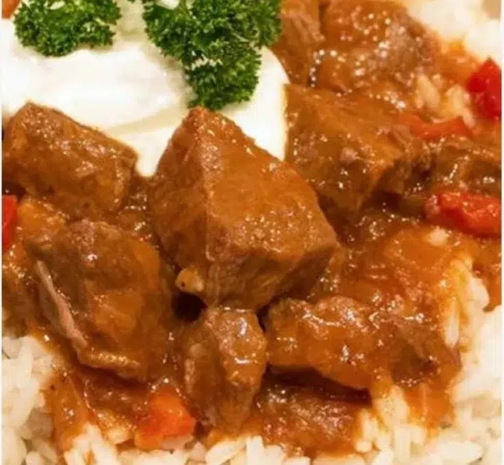 Bowl of Traditional German Goulash topped with fresh herbs.