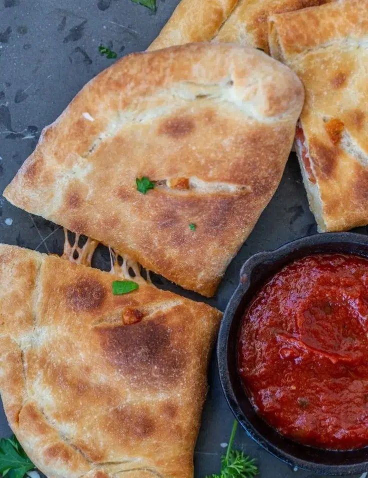 Golden brown air fryer calzones filled with cheese and pepperoni