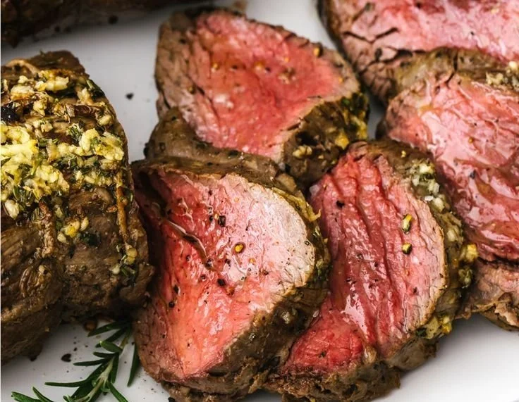 Juicy and perfectly cooked beef tenderloin on a cutting board
