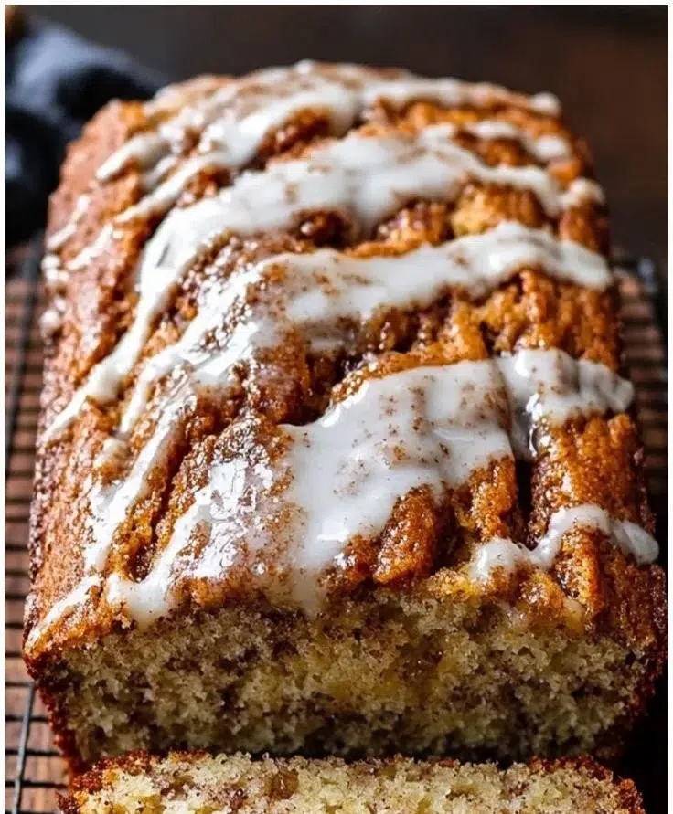 Cinnamon swirl banana bread loaf with sliced pieces on a wooden table