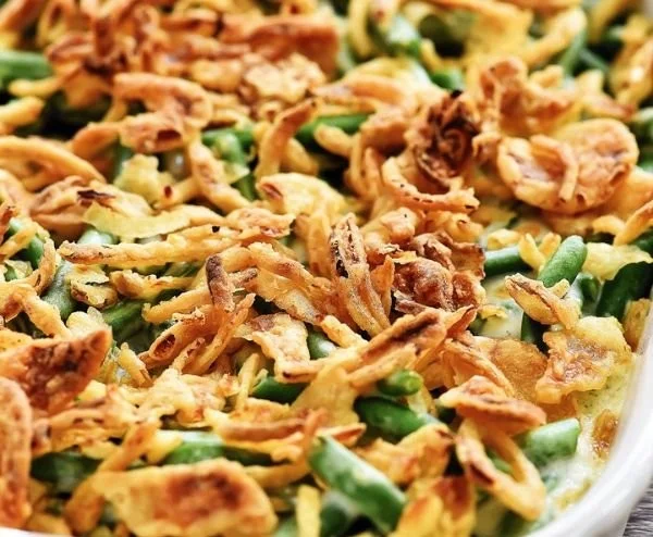 Creamy green beans topped with crispy fried onions in a serving dish