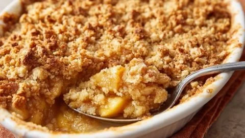 Delicious gold-brown apple crumble topped with a golden crust and served in a baking dish.
