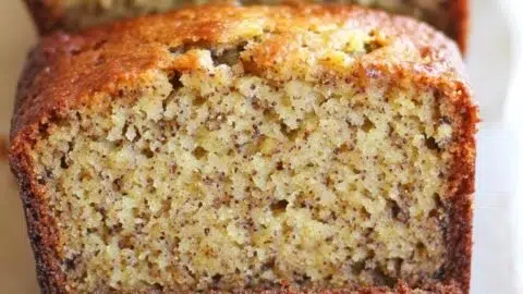 Moist and delicious banana bread recipe sliced on a wooden cutting board