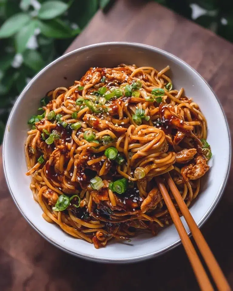 Sticky Garlic Chicken Noodles Recipe 2 Plate of Sticky Garlic Chicken Noodles garnished with green herbs